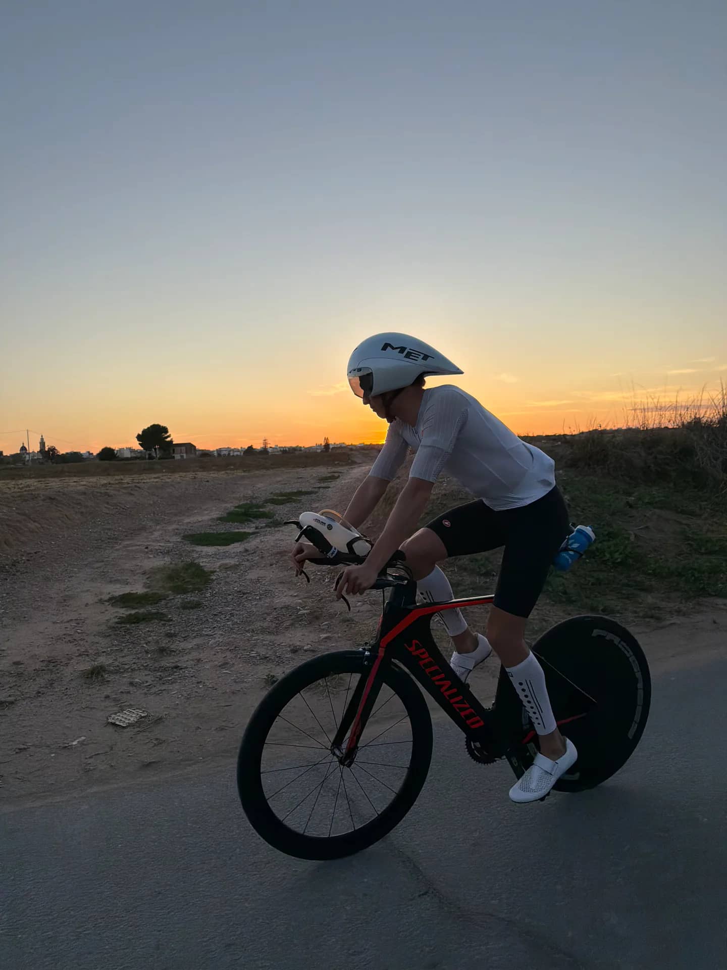 Diego Martí pedalea en bicicleta de contrarreloj al atardecer.